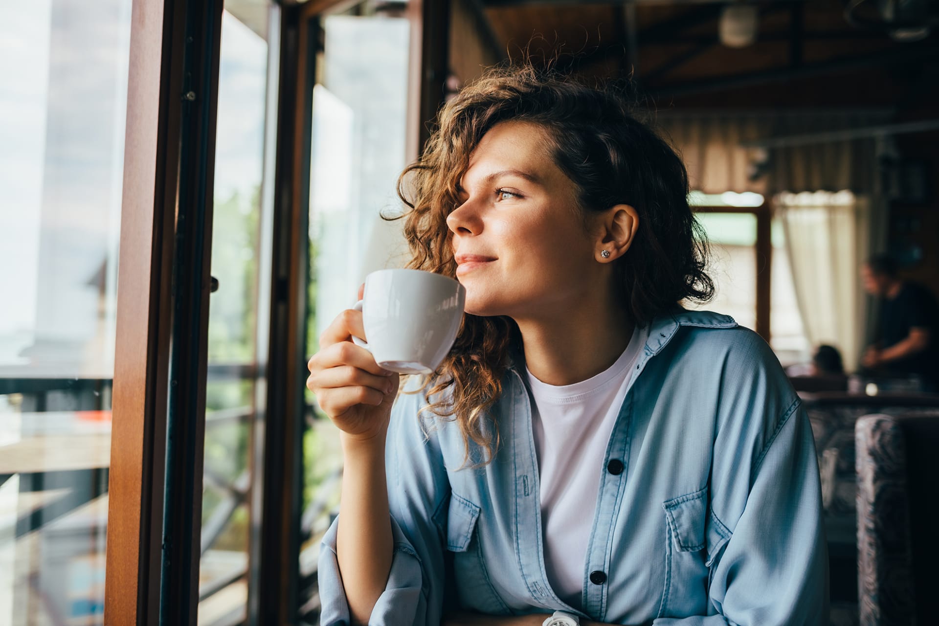 happy young woman looking out window 800